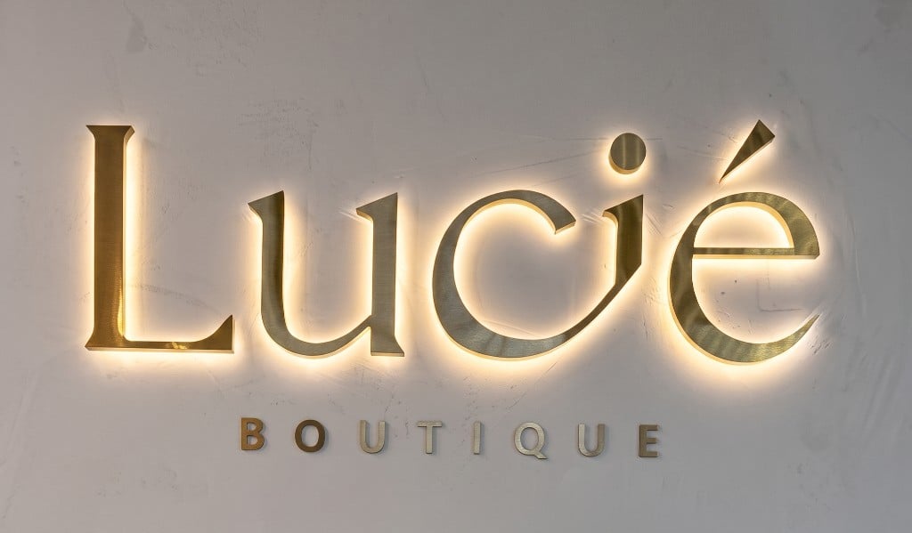 Why Choose Custom LED Backlit Signs for Business Lucie Boutique custom LED backlit business sign with warm halo glow